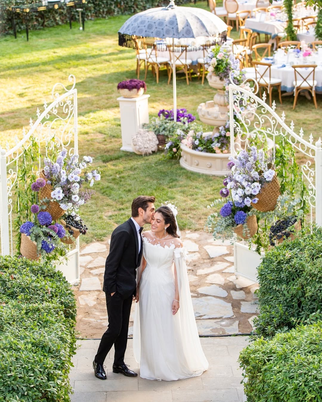 Groom kissing bride at garden gate